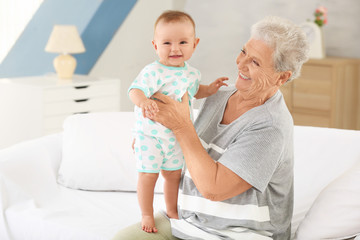 Senior woman with her little grandchild resting at home