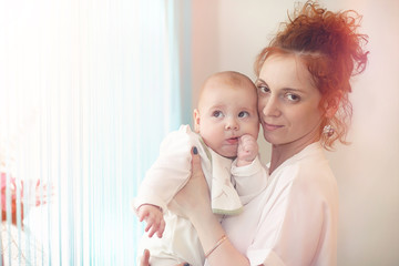 Baby in the arms of the girl. Mom holds her child in her arms. H