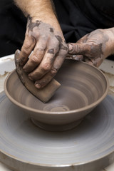 Artist makes clay pottery on a spin wheel