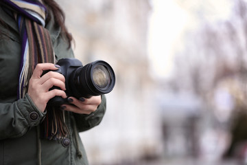 Young photographer with camera, outdoors