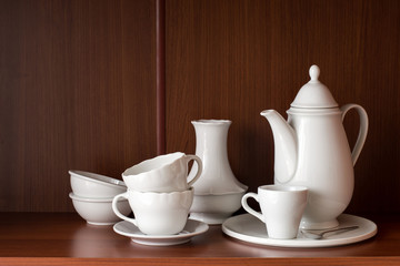Fototapeta na wymiar White porcelain tableware for coffee, located on a shelf in the closet.