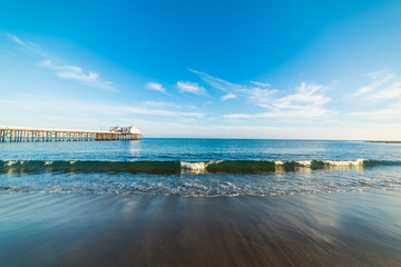 Small wave by the pier in Malibu beach - obrazy, fototapety, plakaty