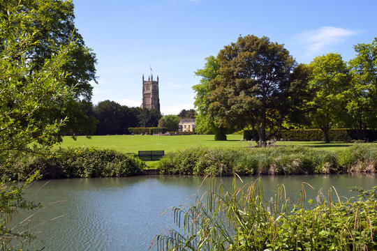 Tower of the landmark Abbey Church seen across Abbey Grounds in spring sunshine, Cirencester, The Cotswolds, Gloucestershire, UK