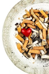 Cigarettes in a glass ashtray on a white background. Treatment of lung cancer. Tobacco industry.