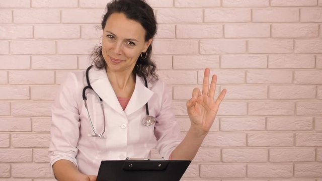A female with a tablet. A doctor with a tablet shows a gesture perfectly.