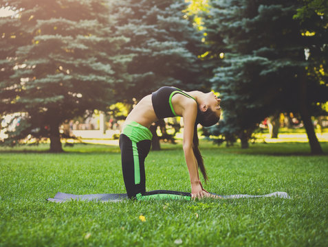 Woman Training Yoga In Table Top Pose Outdoors