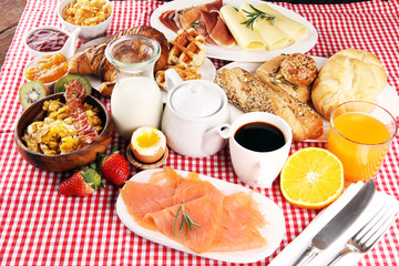 breakfast on table with waffles, croissants, coffe and juice