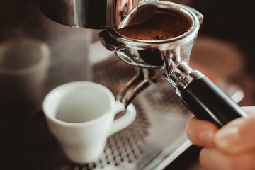 Prepare making hot coffee espresso in white glass cup at coffee machine