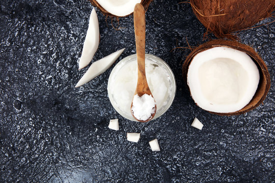 coconut oil and fresh coconuts on grey background.