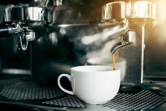 Prepare making hot coffee espresso in white glass cup at coffee machine