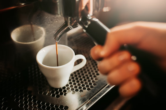 Prepare making hot coffee espresso in white glass cup at coffee machine