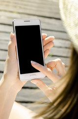 Close Up Business Woman in hat Using Smartphone Mobile Phone Outdoor Black Oled Display Wooden Background Stylish Summer Dressed hipster