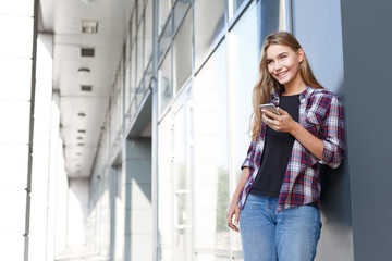 Happy young woman using smartphone outdoors