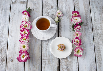 Bouquet of beautiful flowers with cup of tea and cake. Holidays background: March 8, valentine's day, mother's day, wedding, engagement