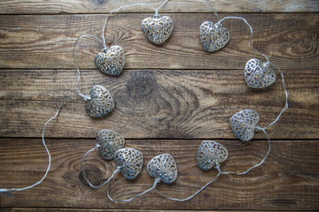 silver of garland of hearts on wooden background