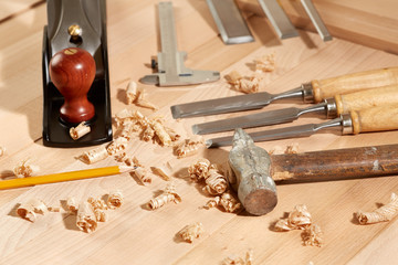 .DIY concept. Woodworking and crafts tools. Carpentry hand tools on a workbench. Planers, chisels, measuring tools.  Wooden parts, planks and stocks. Wooden background.