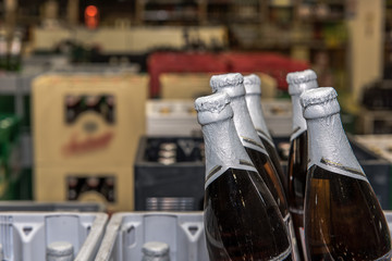 Beer bottles are stacked reusable containers are in a beverage market. Crate with full beer bottles. Focus on the bottles. Concept: drinks