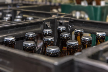 View into a beer crate standing in a beverage market. Crate with full beer bottles. Focus on the...