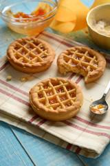 small pies with ingredients around on light blue table