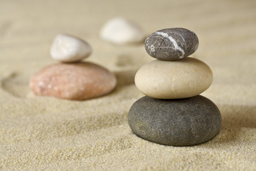 Fototapeta na wymiar Pile of balanced stones on sand