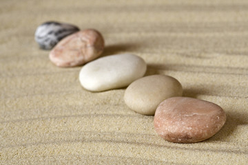 Fototapeta na wymiar Row of pebbles on sand