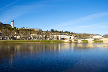 Naklejka na ściany i meble Chinon town with its chateau on the hill above in spring afternoon sunshine on the banks of the River Vienne, Indre-et-Loire, France