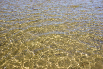 Fototapeta na wymiar Texture of transparent sea waves in sunlight