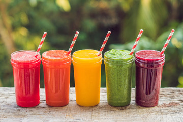 Rainbow from smoothies. Watermelon, papaya, mango, spinach and dragon fruit. Smoothies, juices, beverages, drinks variety with fresh fruits on a wooden table
