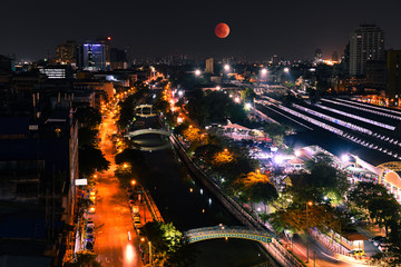 Super Blood moon in the sky. With high angle view of Bangkok at night.