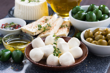 cheeses - mozzarella, feta cheese and pickles on table
