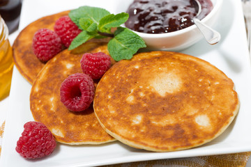 delicious pancakes with raspberries and jam for breakfast, closeup