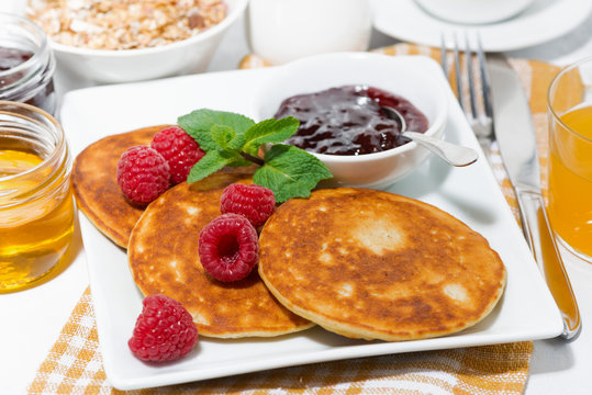 delicious pancakes with raspberries and jam for breakfast