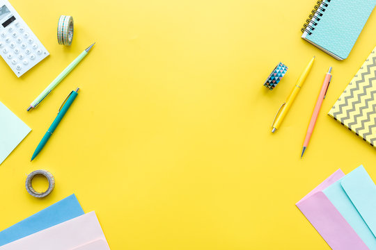 Scattered Stationery On Student's Desk. Yellow Background Top View Copy Space