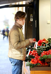 Young man buying vegetables at the market