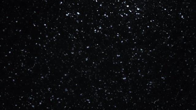 Natural snow in slow motion on a black background
