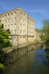 Fototapeta na wymiar Picturesque old industrial architecture by the River Avon in spring sunshine, Bradford on Avon, Wiltshire, UK