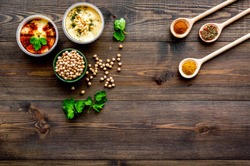 Cook chickpeas. Make hummus. Bowls with grains and ready meal near spices on dark wooden background top view copy space