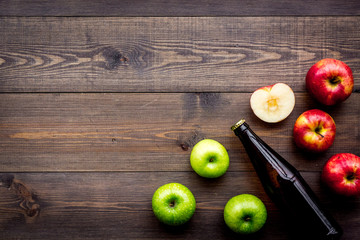Apple cider. Low-alcoholic beveradge in dark bottle on dark wooden background top view copy space