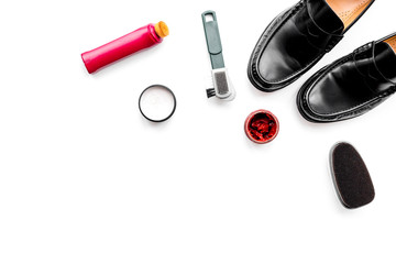 Shoe care products. Leather men shoes, shoe polish, brushes, wax on white background top view copy space