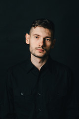 Man in headphones and black shirt on a black background