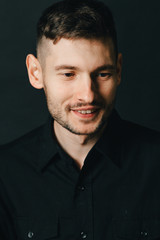 Fototapeta premium Man in headphones and black shirt on a black background