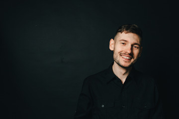Naklejka premium Man in headphones and black shirt on a black background