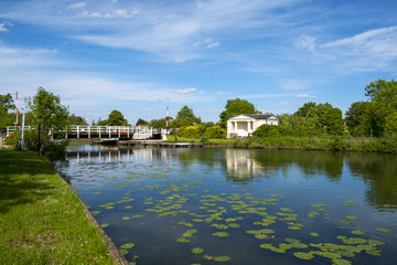 Fototapeta premium Late spring sunshine on Splatt Bridge and bridge keepers cottage on the Gloucester & Sharpness Canal at Frampton on Severn, Gloucestershire, UK