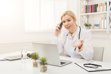 Emotional doctor talking on the phone with her patient