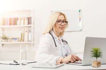 Portrait of female doctor sitting at the desktop