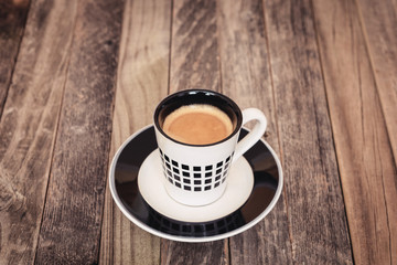 Single small coffee cup on wooden background