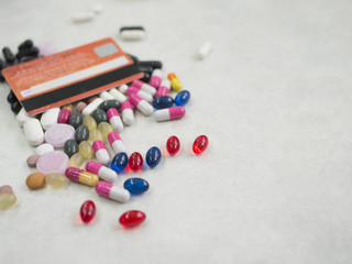 Many colorful pills medicine with credit card on a white background