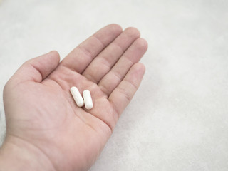 two white pills in a hand
