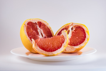 Mature grapefruit on a white plate close-up