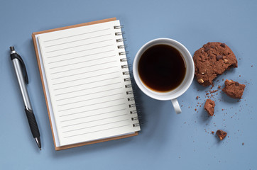 Notebook and coffee with cookie